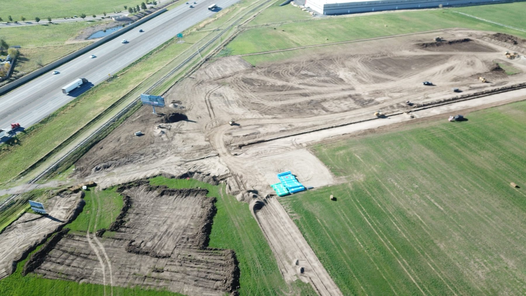 Aerial view of the Payson Central site showing graded pads, equipment, and stacked utility materials